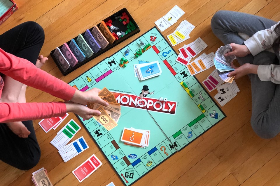 Zwei Kinder spielen Monopoly.