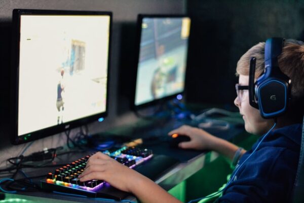 Ein Junge mit Brille sitzt vor einem Computerbildschirm