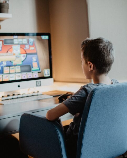 Ein Junge sitzt vor einem Computer und spielt