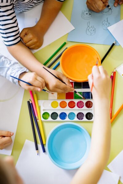Drei Kinder malen mit Wassermalfarbe