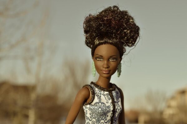 Eine Barbie mit dunkler Haut und lockigem Haar. 