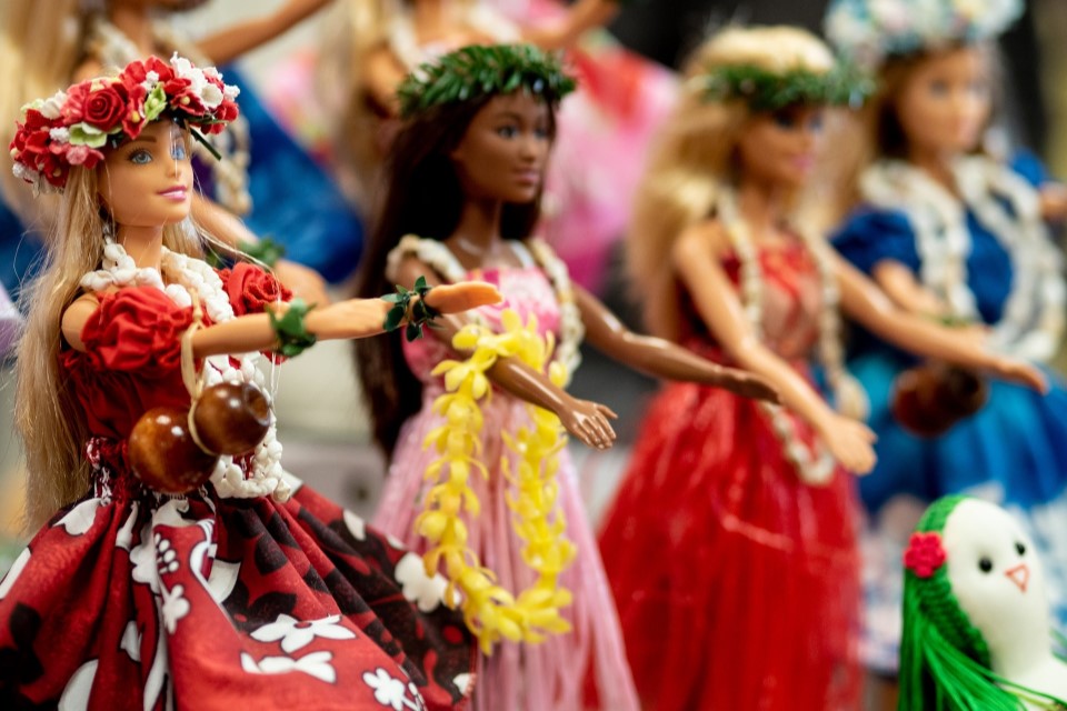 Verschiedene Barbie-Puppen mit unterschiedlichen Hautfarben in bunten Kleidern.
