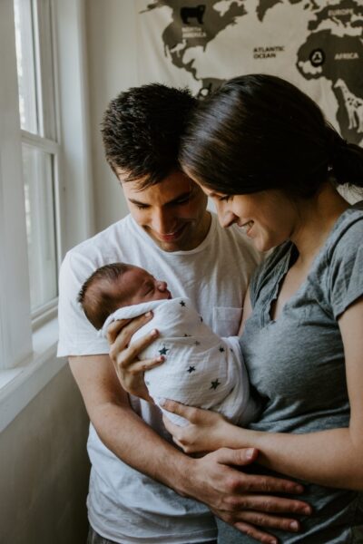 Ein Paar hält ein neugeborenes Kind
