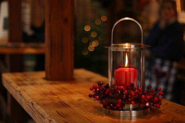 Eine weihnachtlich geschmückte Laterne mit roter Kerze. 