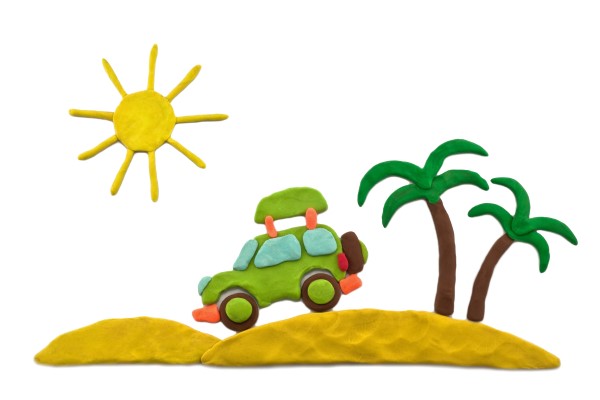 Aus Knetmasse ist ein Strand mit Palmen geformt auf dem ein Auto fährt.