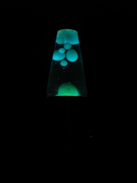 Eine fluoreszierende Lavalampe leuchtet in der Dunkelheit. 